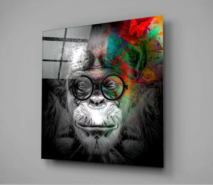 Angled view of glass wall art featuring a bearded face with round glasses, monochrome left side and vibrant multicolored right side with splatter effects.