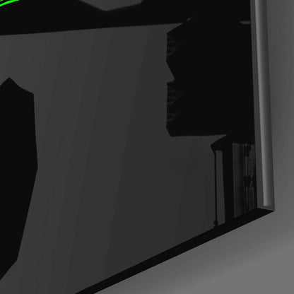 Close-up side angle of black glass wall art panel showing edge detail and reflective surface against gray background.
