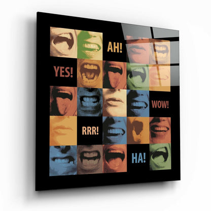 Square glass wall art with colorful pop-art grid of expressive faces and mouths in orange, blue, green, and yellow tones with text reading "YES!", "AH!", "WOW!", "RRR!", and "HA!" on black background, viewed at an angle.