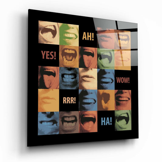 Square glass wall art with colorful pop-art grid of expressive faces and mouths in orange, blue, green, and yellow tones with text reading "YES!", "AH!", "WOW!", "RRR!", and "HA!" on black background, viewed at an angle.
