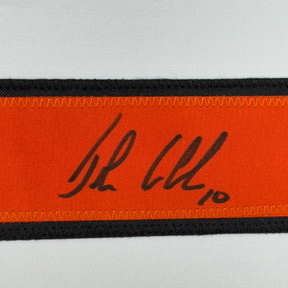 Close-up of signed orange and black ribbon strip showing handwritten signature "JL LeClair" in black ink.