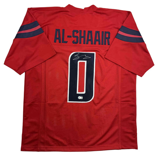 Red football jersey with "AL-SHAAIR" printed across shoulders, navy number "0" on chest, and navy stripes on sleeves, displayed flat against white background.