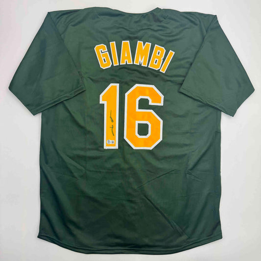 Green Oakland Athletics baseball jersey with "GIAMBI" and number "16" in yellow and white lettering, displayed flat against white background.