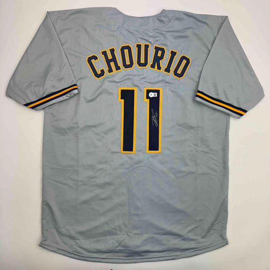 Gray baseball jersey laid flat displaying "CHOURIO" and number 11 in yellow and navy with autographed signature on chest.