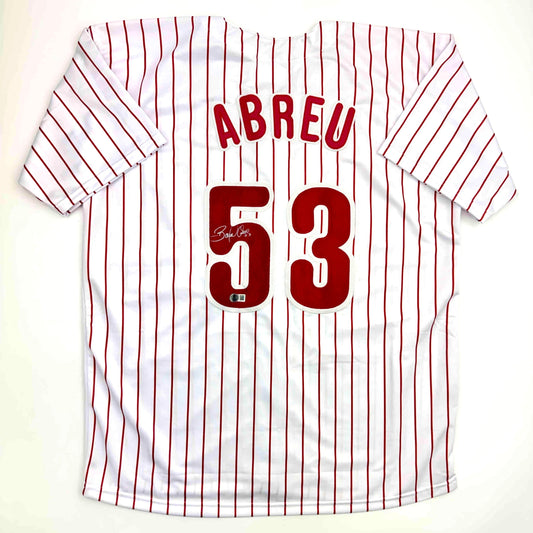White pinstriped baseball jersey with red vertical stripes, red "ABREU" text across chest, red numbers "53" below, displayed flat against neutral background.