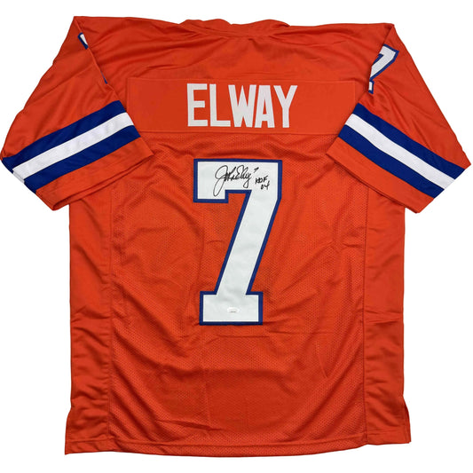 Flat lay of orange Denver Broncos jersey number 7 with "ELWAY" nameplate and autographed signature, navy and white sleeve stripes visible.