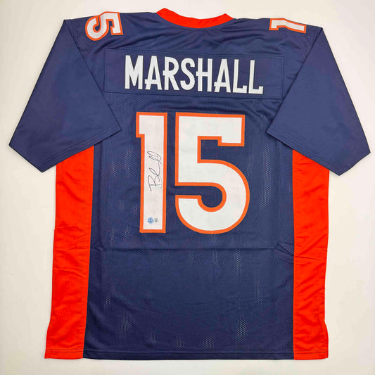 Back view of navy and orange Denver Broncos jersey number 15 with "MARSHALL" nameplate and autographed signature.