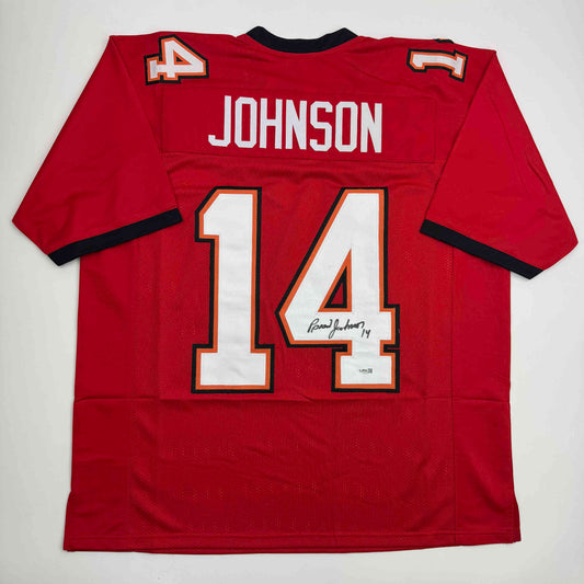 Back view of red Tampa Bay football jersey number 14 with "JOHNSON" nameplate and autographed signature on white numerals.