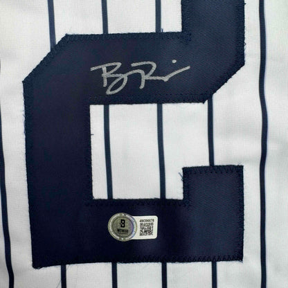 Close-up of signed navy pinstripe jersey back with JSA authentication hologram and QR code visible on white pinstriped fabric.