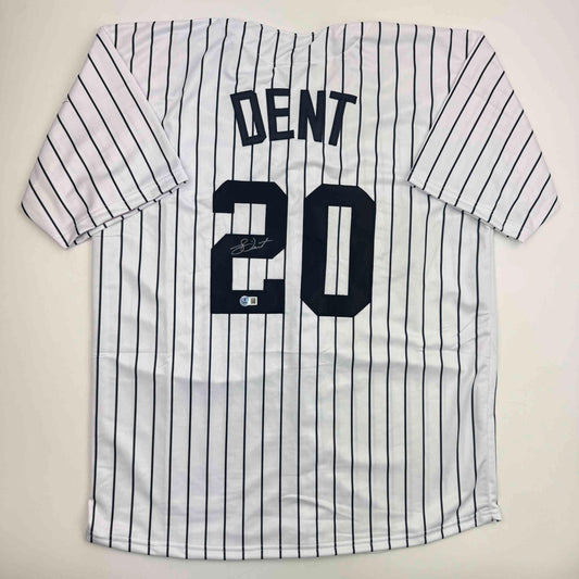 White pinstriped baseball jersey with "DENT" and number "20" in black lettering, displayed flat against white background with visible autograph.