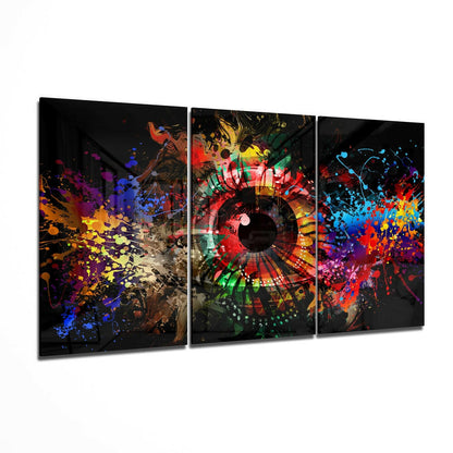 Three-panel glass wall art with vibrant splattered paint effects and a circular geometric design in the center panel against a black background.