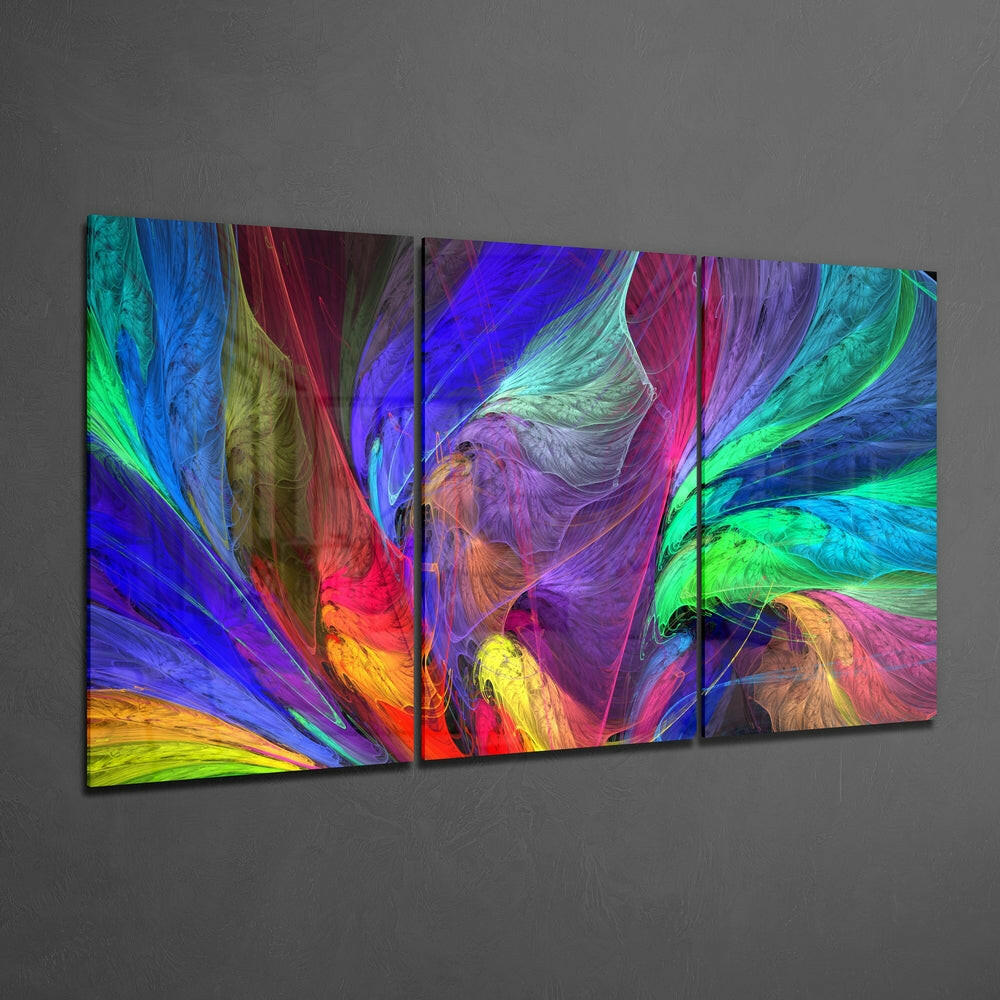 Three-panel glass wall art displaying swirling abstract patterns in vibrant blues, greens, purples, reds, and yellows mounted on gray wall.