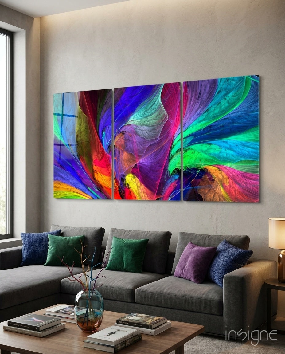 Vibrant multi-panel glass art displaying swirling abstract colors in blues, purples, greens, and reds hung above a gray sectional sofa in a living room.