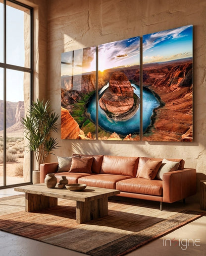 Modern living room with rust-colored leather sofa displaying three-panel glass wall art of Horseshoe Bend canyon landscape at sunset.