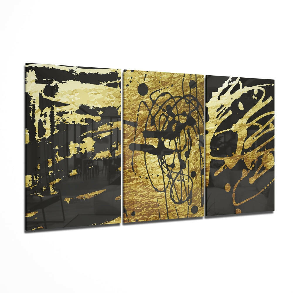 Three-panel glass wall art with gold and black abstract doodle designs displayed at an angle.