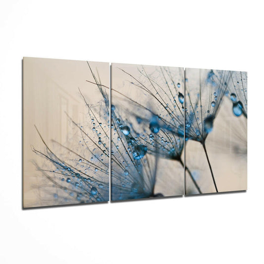 Three-panel glass wall art displaying dandelion seeds with blue water droplets against a soft beige background.