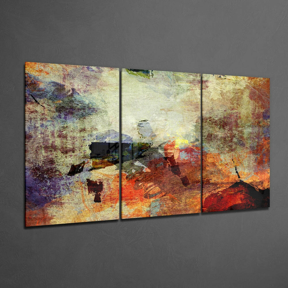 Three-panel abstract glass wall art displaying layered textures in rust, orange, yellow, purple, and teal tones mounted on gray wall.