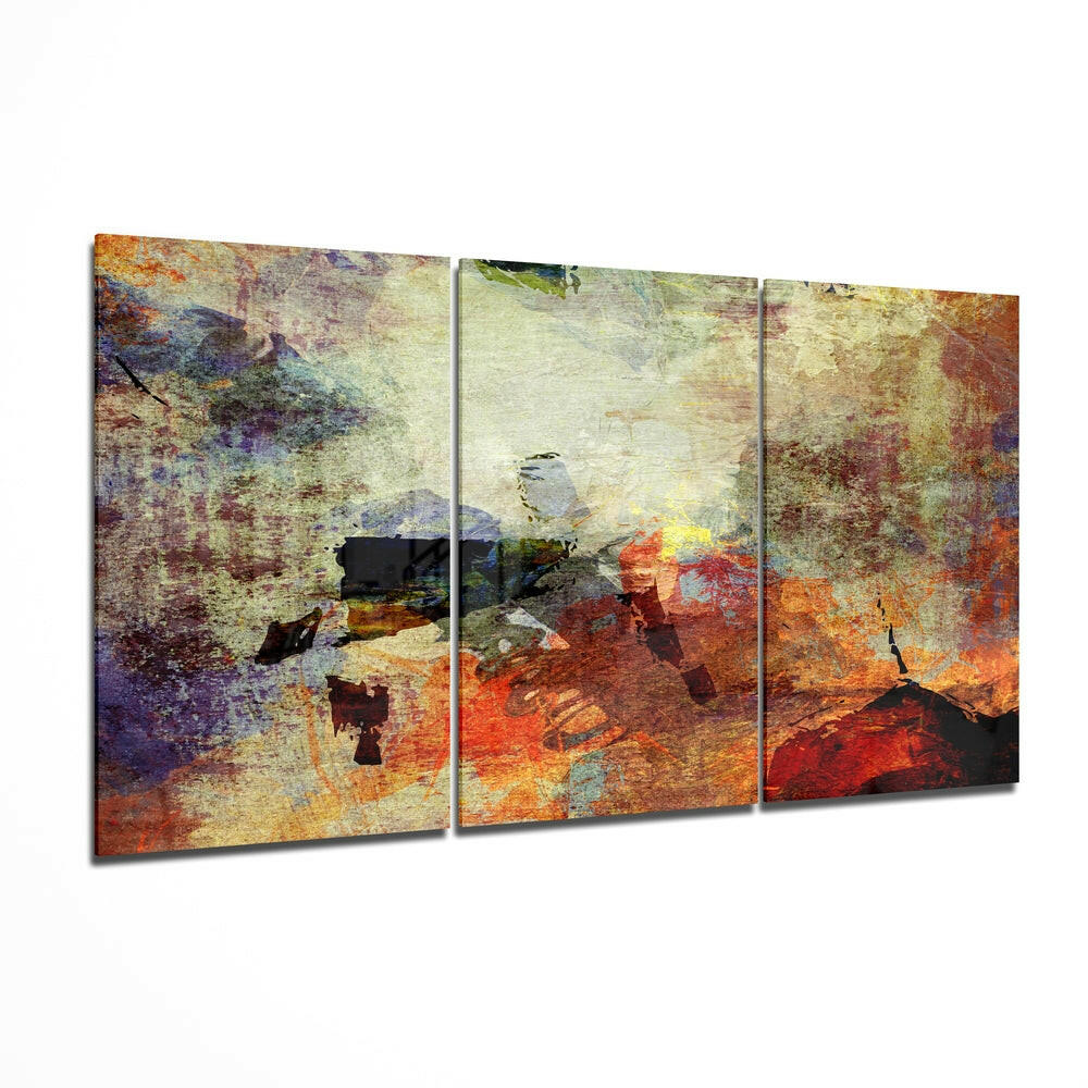 Three-panel glass wall art with abstract textured layers in rust, orange, yellow, blue, and purple tones displayed at an angle.