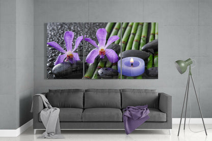 Purple orchid glass wall art triptych displayed above gray sofa in minimalist interior setting.