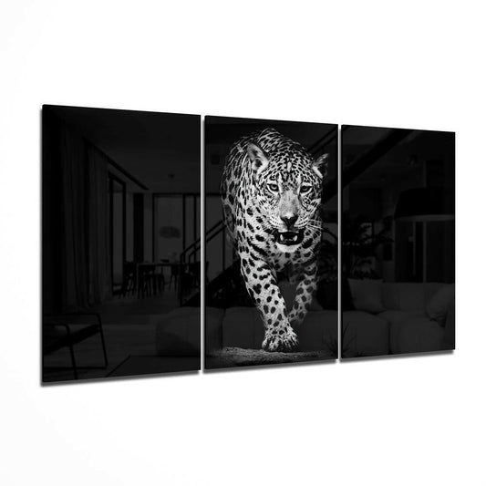 Three-panel black and white glass wall art displaying a leopard walking forward in center panel with dark architectural spaces on flanking panels.
