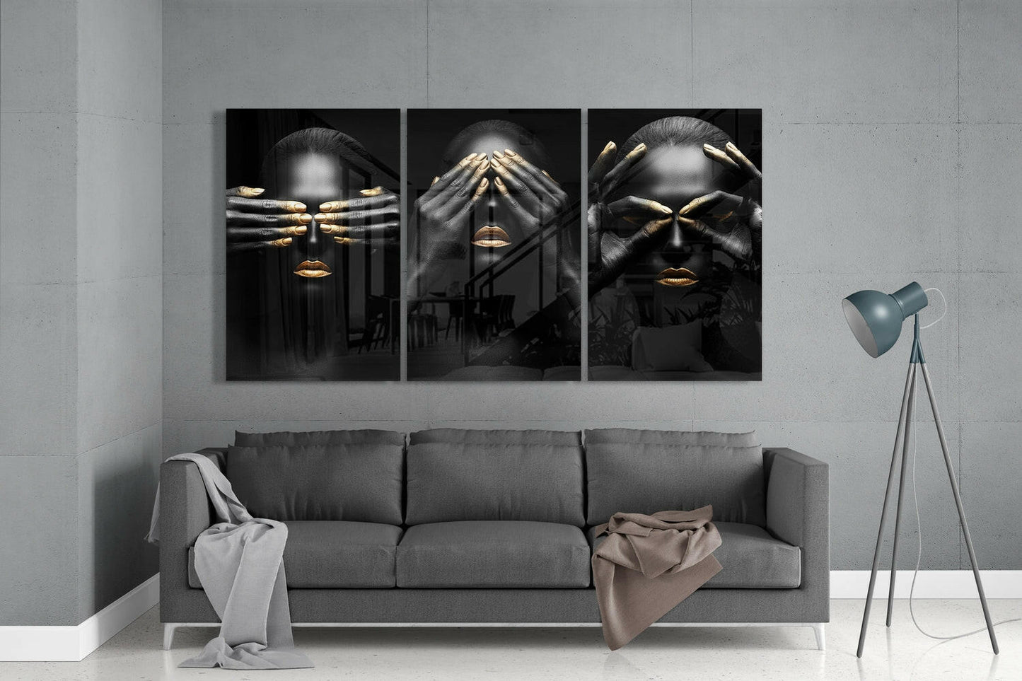 Three black glass panels with gold-accented faces and hands displayed above gray sofa in modern living room interior.