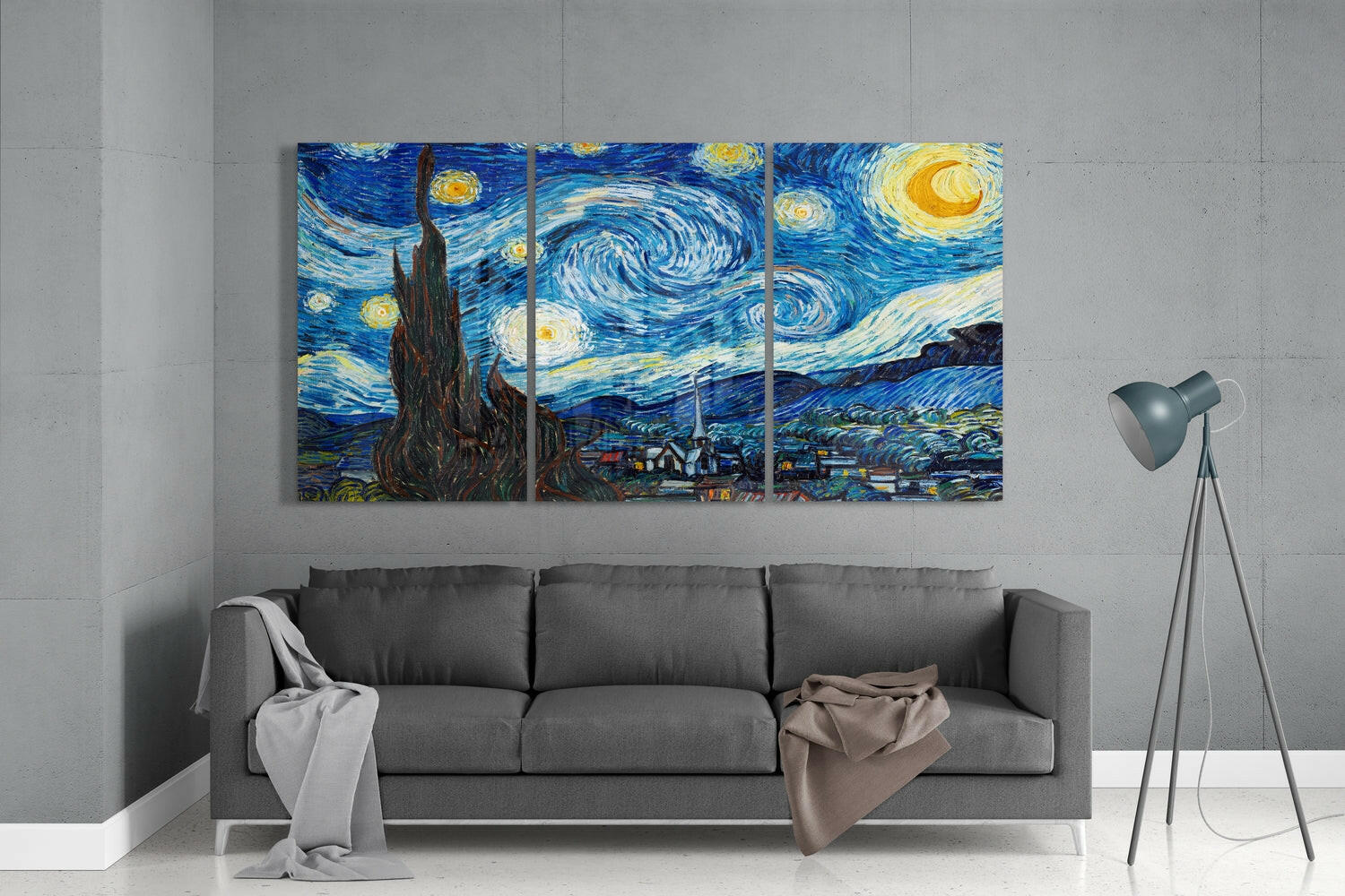 Three-panel glass wall art of Van Gogh's Starry Night hanging above gray sofa in minimalist interior space.