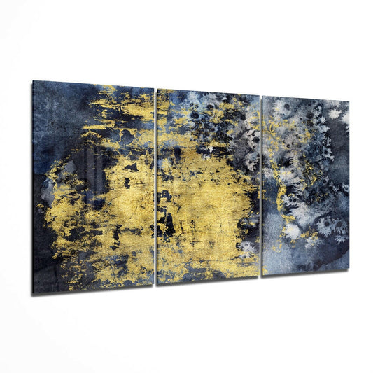 Three-panel glass wall art displaying dark blue and gray tones with gold and yellow distressed paint splatters and weathered texture effects.