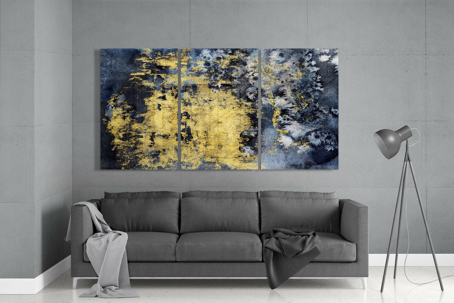 Three-panel gold and dark blue textured glass art displayed above gray sofa in modern living room.