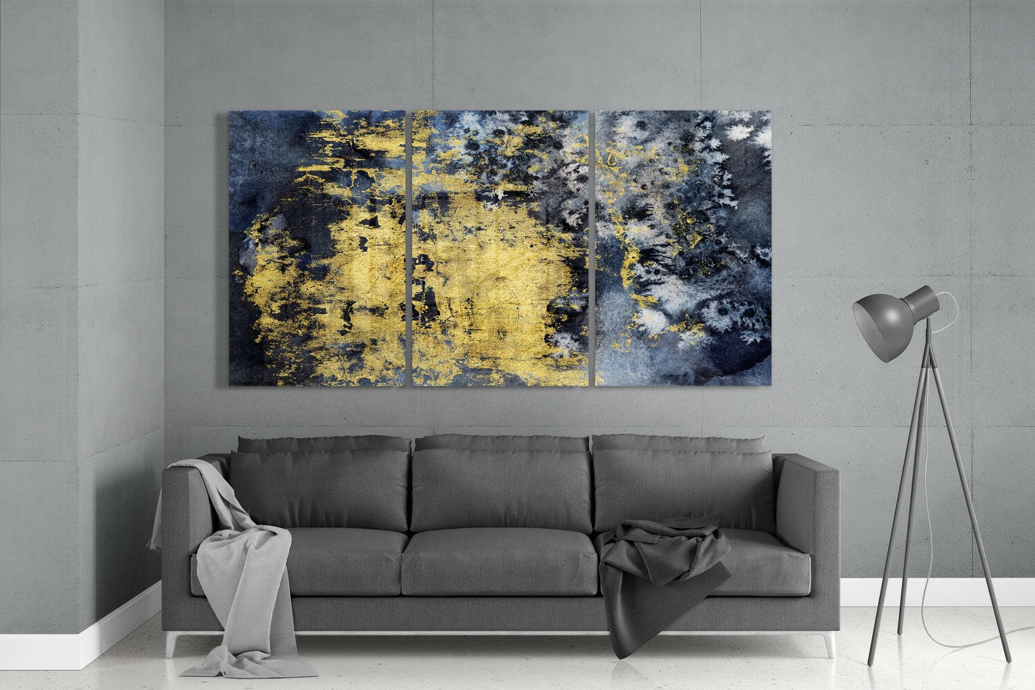 Three-panel gold and dark blue textured glass art displayed above gray sofa in modern living room.