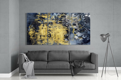 Three-panel gold and dark blue textured glass art displayed above gray sofa in modern living room.