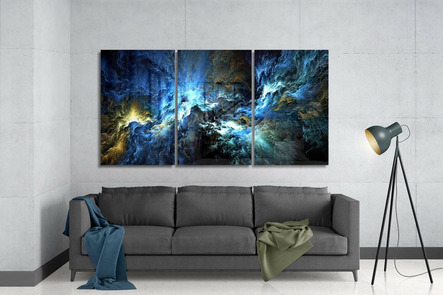 Three-panel blue and gold abstract glass art displayed above gray sofa in modern living room setting.