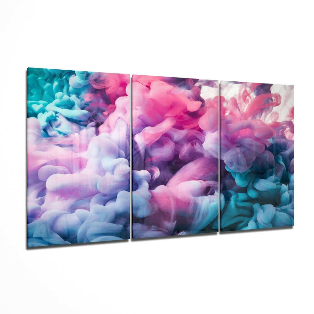 Three-panel glass wall art displaying swirling pastel pink, purple, blue, and white smoke effects in an angled perspective view.
