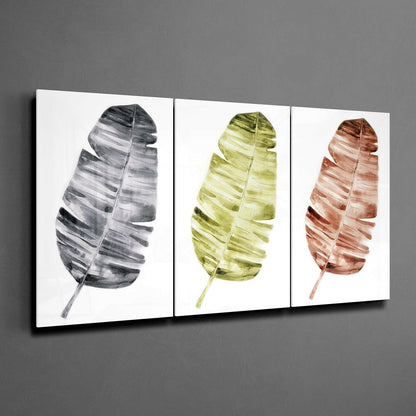 Three glass wall panels displaying watercolor leaves in grayscale, chartreuse, and terracotta tones mounted on gray wall.
