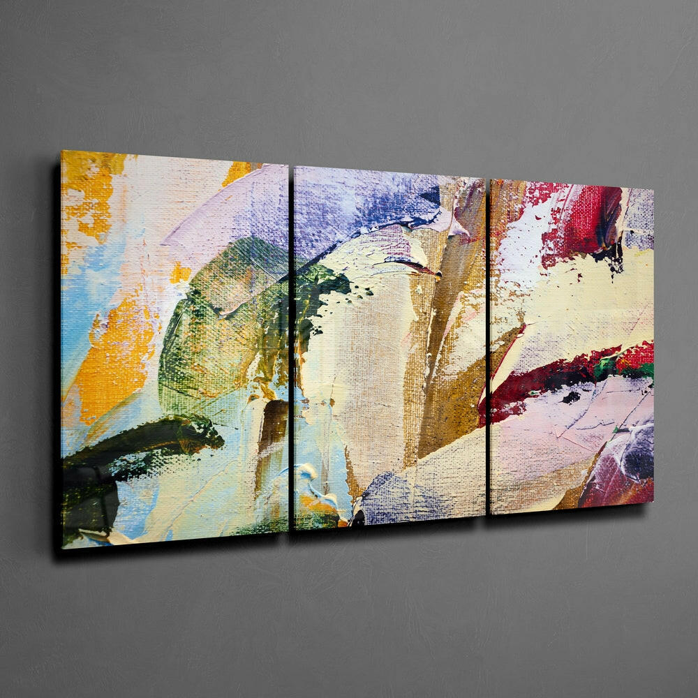 Three-panel abstract glass wall art with multicolored brushstrokes in yellow, green, blue, red, and cream displayed on gray wall.