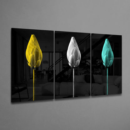 Three-panel glass wall art displaying colorful tulips—yellow, white, and turquoise—against black backgrounds, angled perspective view.