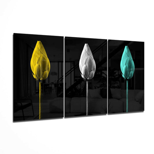 Three-panel glass wall art displaying tulips in yellow, white, and turquoise against black backgrounds, angled perspective view.