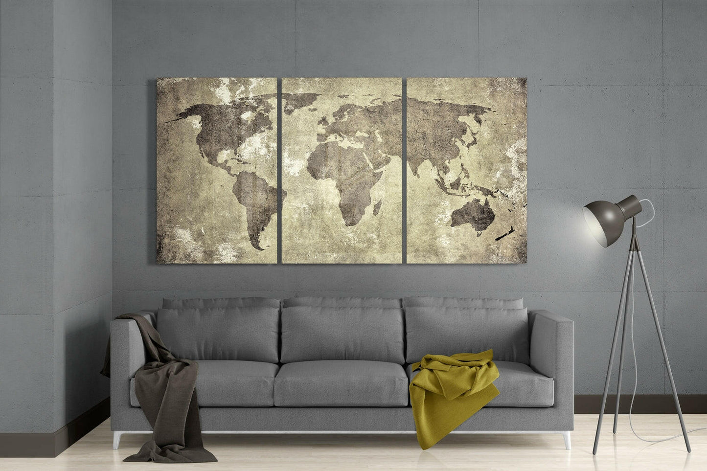Three-panel antique world map wall art in sepia tones displayed above gray sofa in modern living room setting.