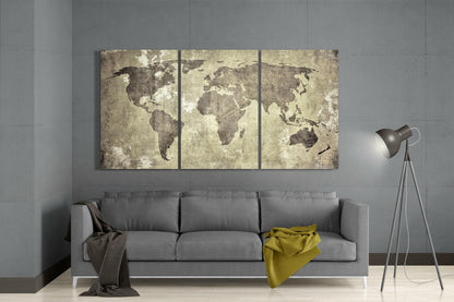 Three-panel antique world map wall art in sepia tones displayed above gray sofa in modern living room setting.