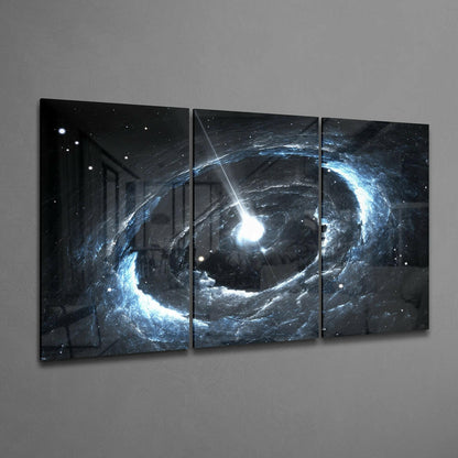 Three-panel glass wall art displaying a glowing blue and white cosmic vortex with bright central beam against a dark starry background.