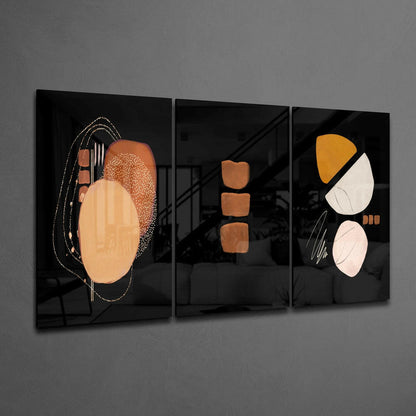 Three black glass panels with abstract geometric shapes in terracotta, cream, yellow, and pink tones displayed on gray wall.