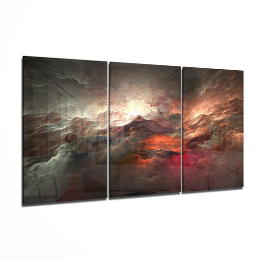 Three-panel glass wall art displaying dramatic storm clouds with orange and red glowing light breaking through gray atmospheric layers.