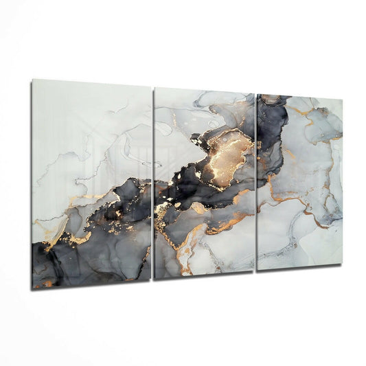 Three-panel glass wall art displaying abstract black, gold, and white marbled patterns with flowing liquid effects.