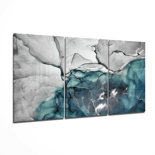 Three-panel teal and gray marble glass wall art displaying aerial landscape with white snow and turquoise water formations.