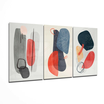 Three glass wall art panels displayed at an angle featuring abstract geometric shapes in red, gray, navy, and peach with black line drawings.