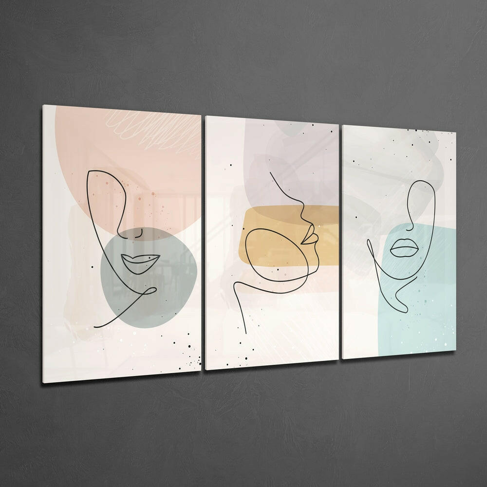 Three framed glass wall panels with minimalist line-drawn faces and pastel watercolor shapes in beige, blue, and gray tones mounted on gray wall.