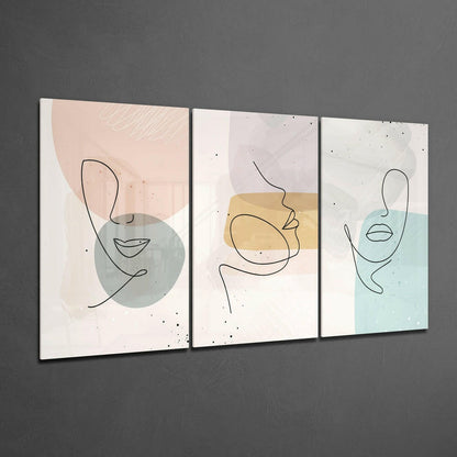 Three framed glass wall panels with minimalist line-drawn faces and pastel watercolor shapes in beige, blue, and gray tones mounted on gray wall.