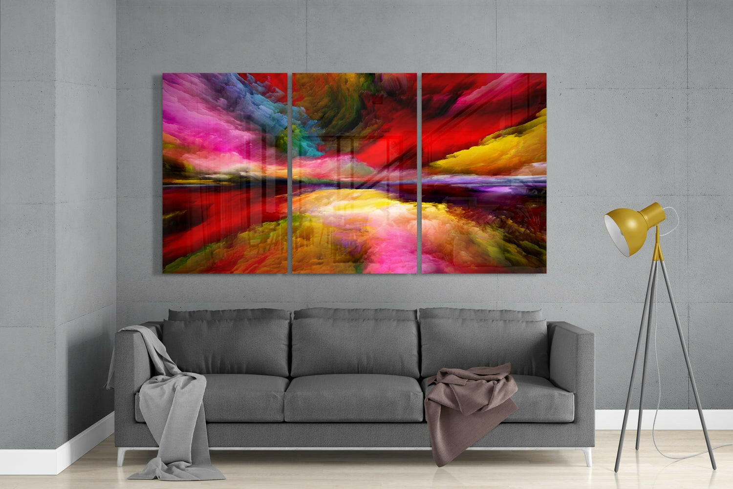 Vibrant multicolored abstract glass triptych mounted above gray sofa in modern living room setting.