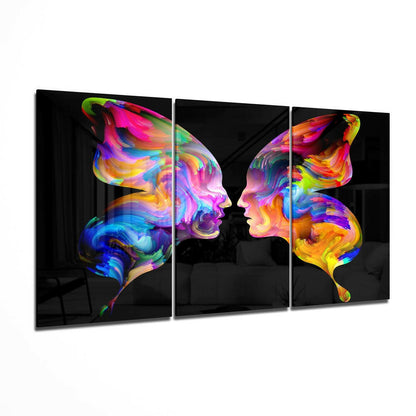 Three-panel glass wall art displaying two colorful silhouetted profiles facing each other with vibrant rainbow swirls in blues, purples, pinks, yellows, and greens against black backgrounds.