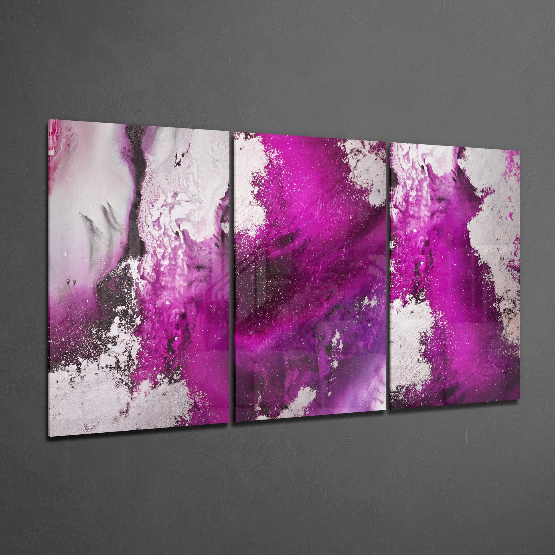 Three-panel fuchsia and white abstract glass wall art mounted on gray wall, angled perspective view.
