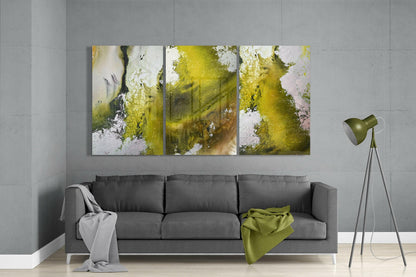 Three-panel abstract green glass wall art displayed above gray sofa in modern living room setting.